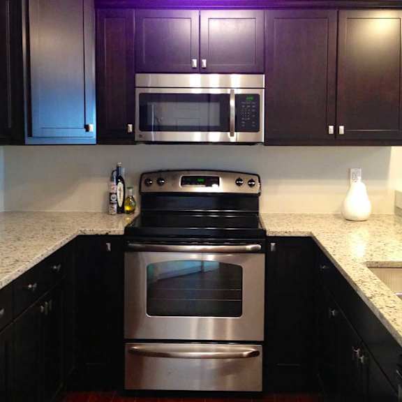 a kitchen with a stainless steel refrigerator, microwave, oven, and sink.