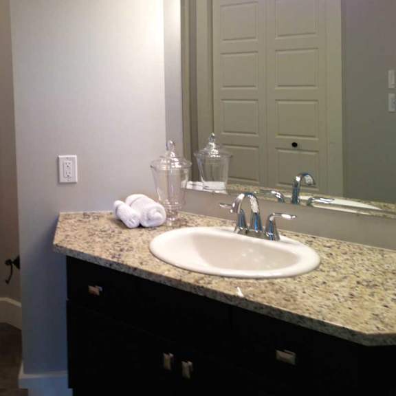 a bathroom with a toilet, sink, and mirror.