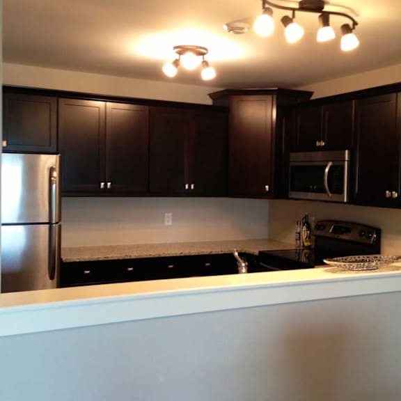 a kitchen with black cabinets and a white counter.