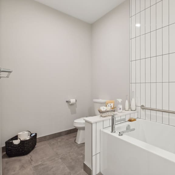 a white bathroom with a tub, toilet, and sink.