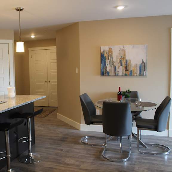 a kitchen with black cabinets and a black bar stool.