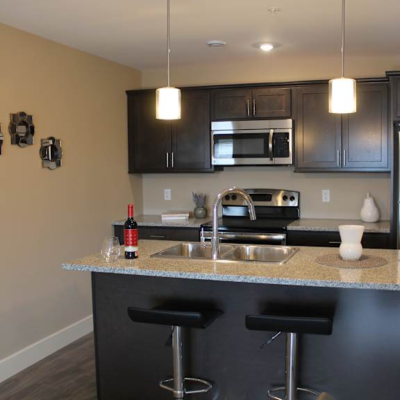 a kitchen with a black counter top and stools.
