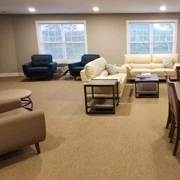 a living room with a carpeted floor and furniture.
