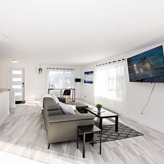 a modern living room with a grey couch and a black coffee table.