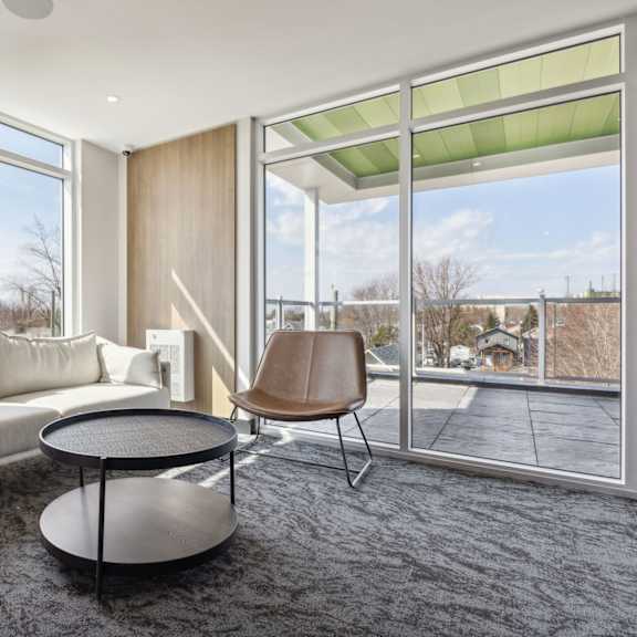 a modern living room with a couch, chair, and a table.