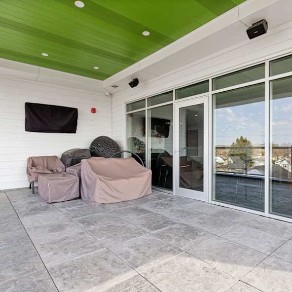 a patio with a grey floor and a green ceiling.