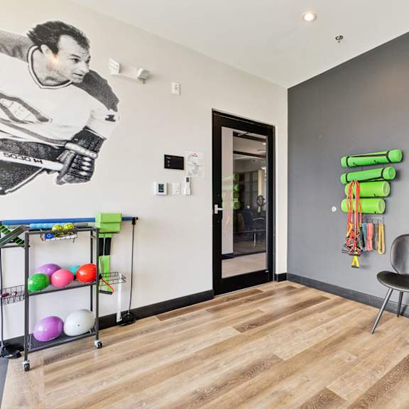 a room with a hockey player mural on the wall and a chair in front of it.