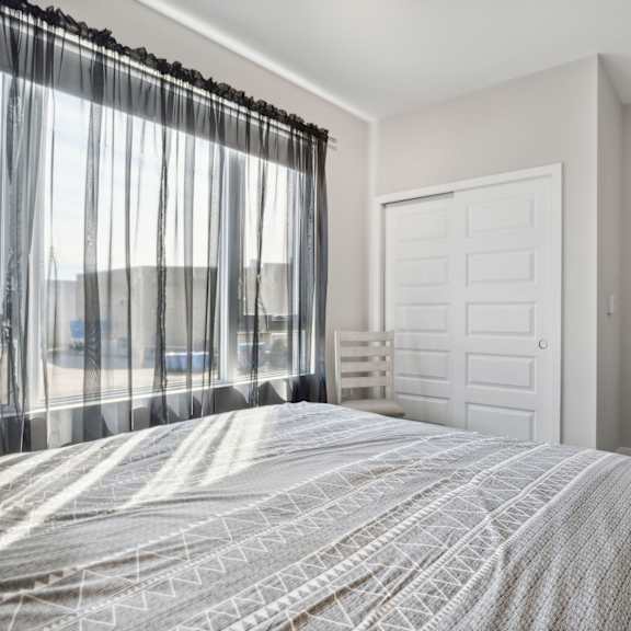 a bedroom with a large bed and a window with curtains.