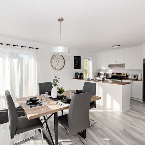 a modern dining room with a wooden table and chairs.