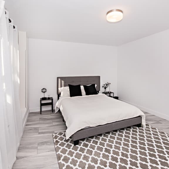 a bedroom with a large bed and a patterned rug.