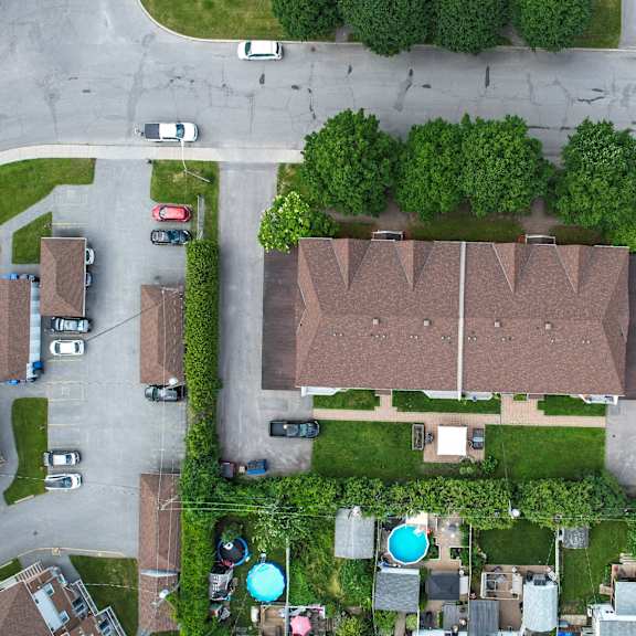 a bird's eye view of a residential area with houses, cars, and trees.