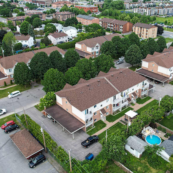a bird's eye view of a residential area with houses, cars, and a swimming pool.