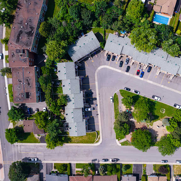 a bird's eye view of a residential area with houses, roads, and trees.