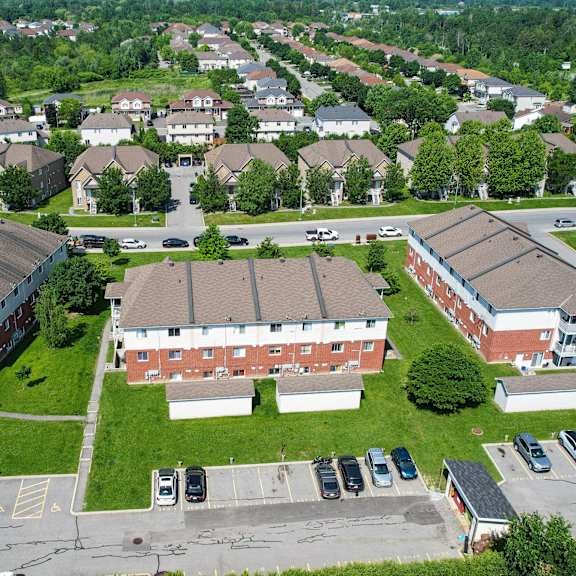 a large red brick building sits in the middle of a green grassy area.