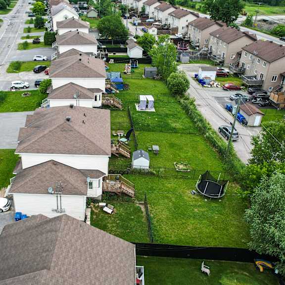 a residential street with houses on both sides and cars parked on the street.