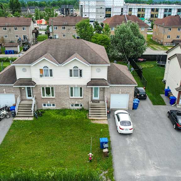 a large house with a driveway and a car parked in front.