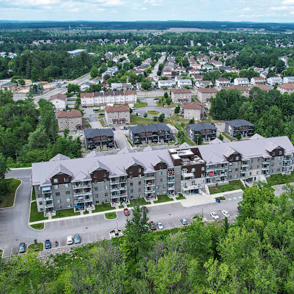 a bird's eye view of a residential area with apartment buildings surrounded by trees.