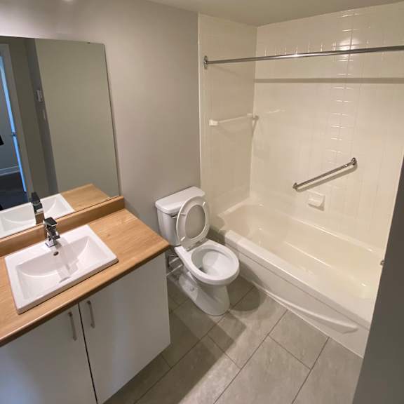 a white bathroom with a toilet, sink, and bathtub.
