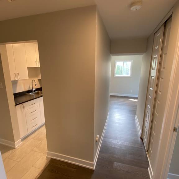 a kitchen with white cabinets and a window.