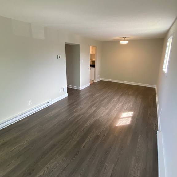 a room with wooden flooring and a door on the left.