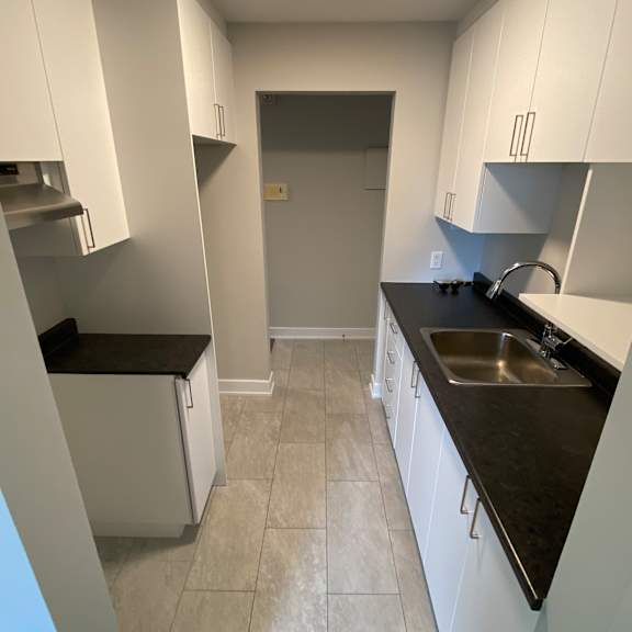 a kitchen with white cabinets and a black countertop.