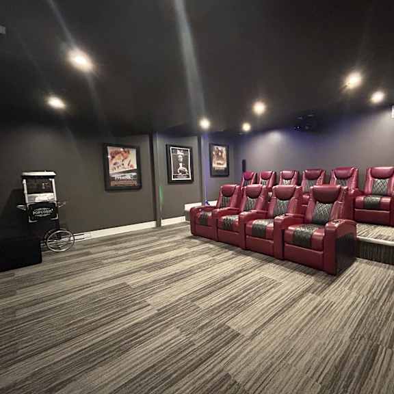a room with a carpeted floor and a row of red chairs.
