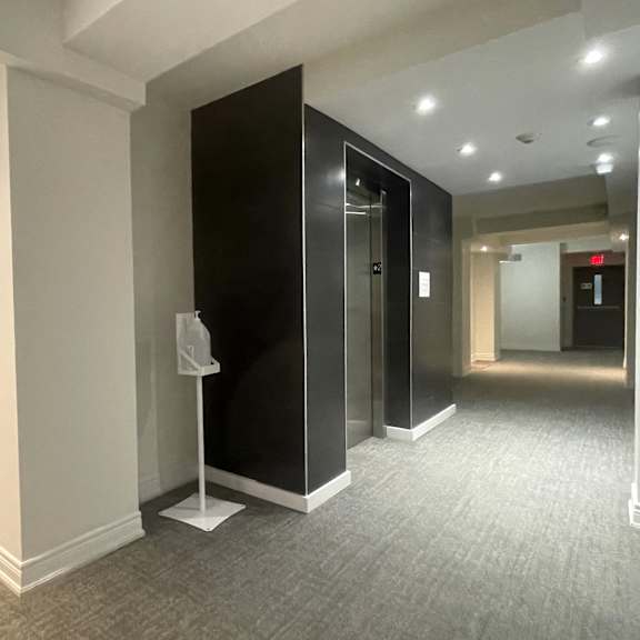 a hallway with a black door and a white door.