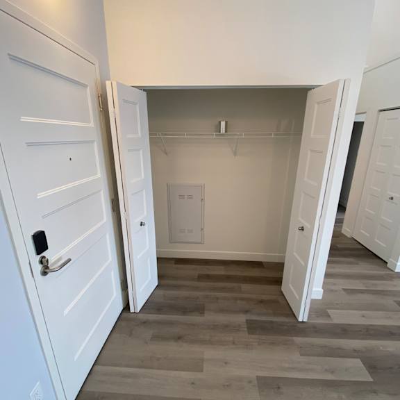 a white door is open to a small bathroom.