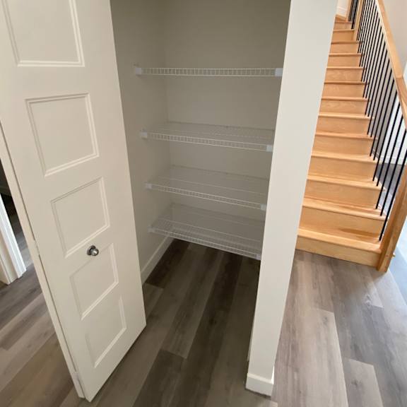 a white door is open to a small pantry.