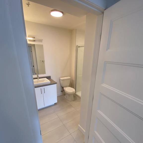 a white bathroom with a toilet, sink, and mirror.