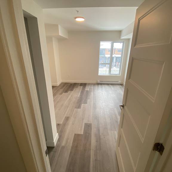 a hallway with wooden floors and white walls.