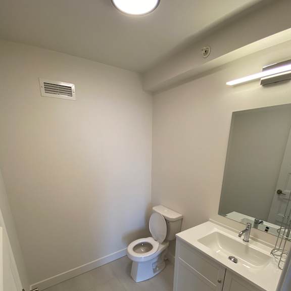 a white toilet sits next to a sink in a small bathroom.