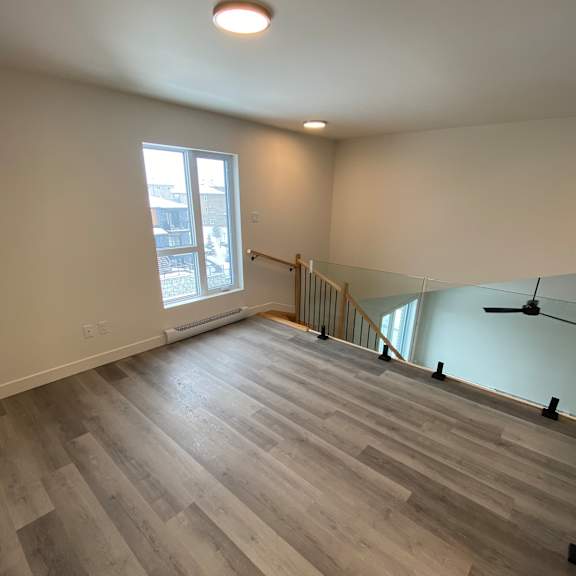 a room with wooden flooring and a window.