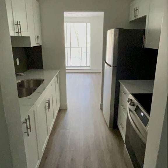 a kitchen with white cabinets and black appliances.