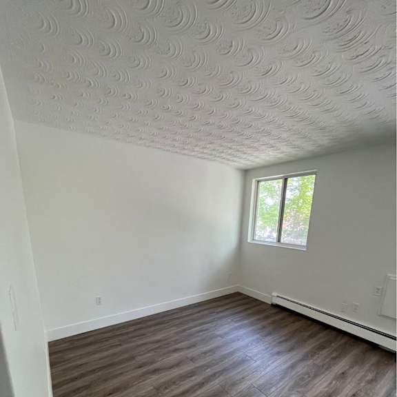 a room with a window and wood flooring.
