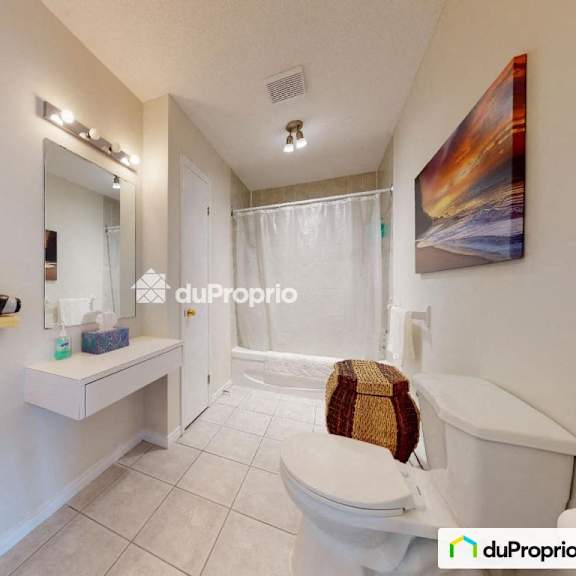 a white bathroom with a toilet, sink, and mirror.
