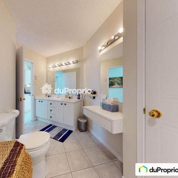 a bathroom with a toilet, sink, and a painting on the wall.