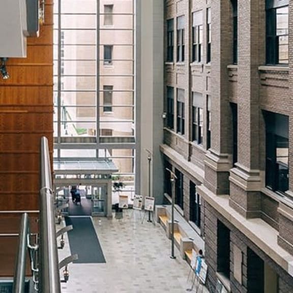 a lobby of a building with stairs and a wood wall