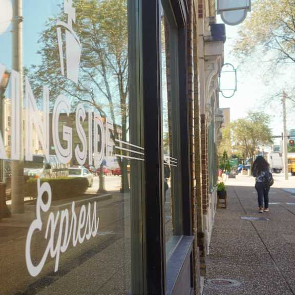 a window display of a grocery store with a person walking down the street