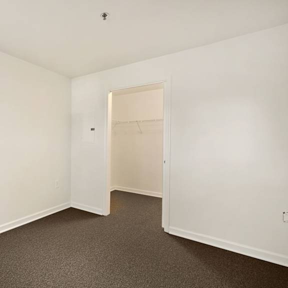 a room with white walls and carpeted floor.