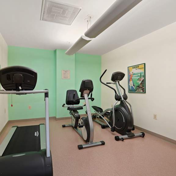 a room with exercise equipment and a green wall.