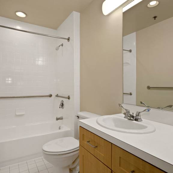 a white bathroom with a toilet, sink, and shower.
