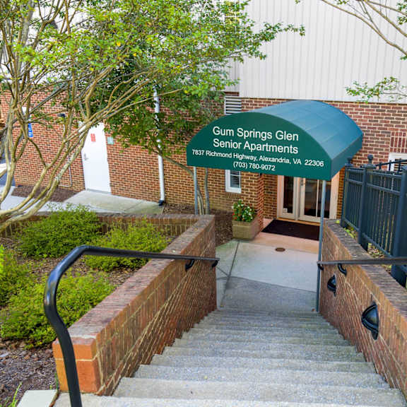 a sign for gum springs glen senior apartments is displayed in front of a building.