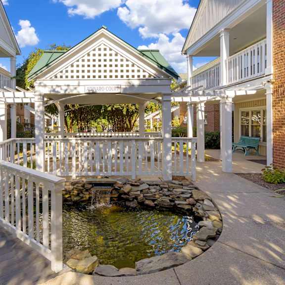 a gazebo with a fountain in the middle of a courtyard.