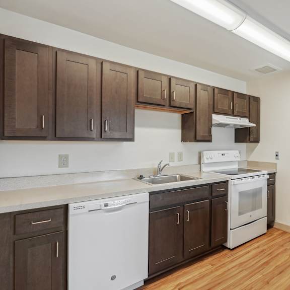 a kitchen with white appliances and brown cabinets.