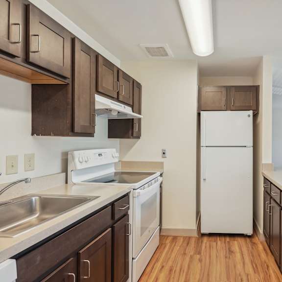a kitchen with white appliances and wooden cabinets.