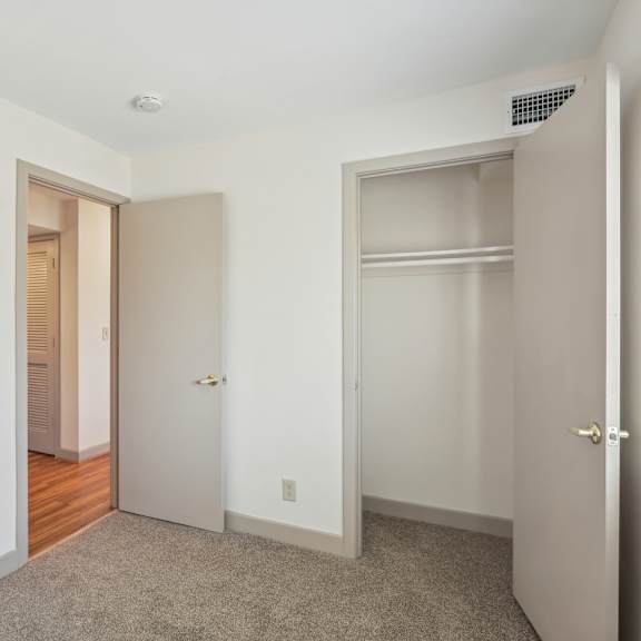 a white room with a carpeted floor and two doors.