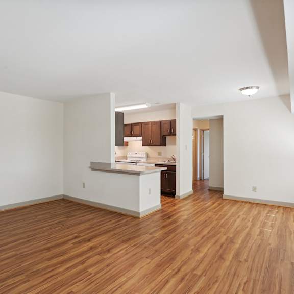a large empty room with wooden floors and white walls.