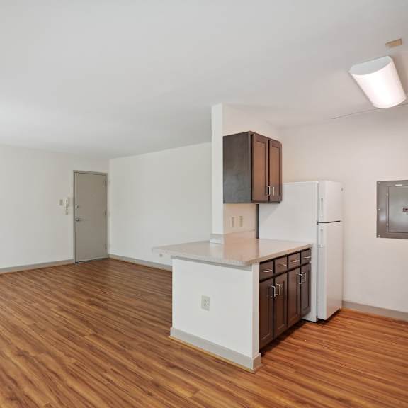 a kitchen with white cabinets and a wooden floor.