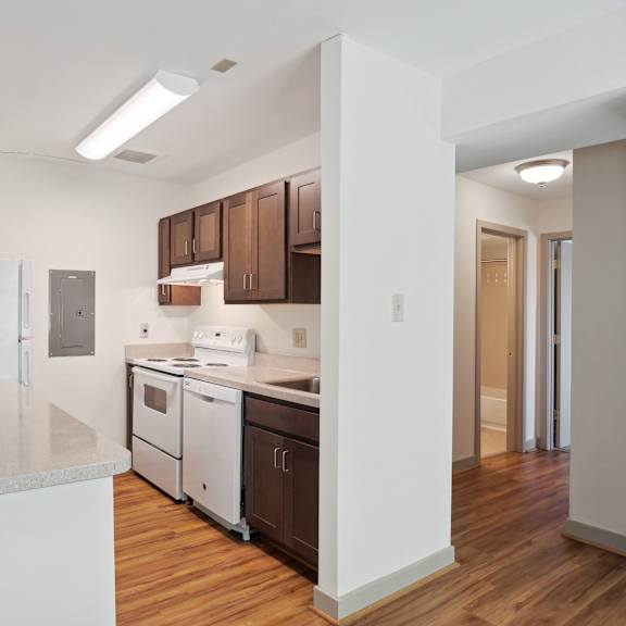 a kitchen with white countertops and wooden floors.